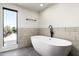 Bright bathroom with a sleek, modern soaking tub and a large window with a view at 4434 E Camelback Rd # 132, Phoenix, AZ 85018