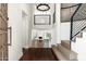Bright foyer featuring wood flooring, statement lighting, and an open staircase leading to the home's living spaces at 4434 E Camelback Rd # 132, Phoenix, AZ 85018
