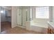 Bright bathroom featuring a tub and shower and tiled floors at 45113 W Buckhorn Trl, Maricopa, AZ 85139