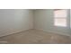 This bedroom has neutral paint, carpet, and a large window with wood blinds at 45113 W Buckhorn Trl, Maricopa, AZ 85139