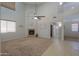 Spacious living room with cozy fireplace and neutral carpeting at 45113 W Buckhorn Trl, Maricopa, AZ 85139