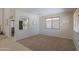 Bright living room featuring neutral paint, plush carpet, and large window with ample natural light at 45113 W Buckhorn Trl, Maricopa, AZ 85139