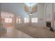 Bright living room with soaring ceilings, fan, fireplace, and large windows at 45113 W Buckhorn Trl, Maricopa, AZ 85139