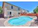 Backyard pool with a stone tile surround, mature landscaping, and a low block wall at 45113 W Buckhorn Trl, Maricopa, AZ 85139