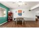 Inviting dining room with wood floors, a rustic table with benches, ceiling fan, and stylish decor at 4712 W Juniper Ave, Glendale, AZ 85306