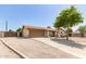Single-story home with a two-car garage and driveway, partially xeriscaped front yard, and tidy landscaping at 4712 W Juniper Ave, Glendale, AZ 85306