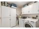 Bright laundry room features white cabinets, washer, and dryer at 4712 W Juniper Ave, Glendale, AZ 85306