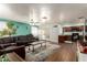 Spacious living room featuring a comfortable leather sofa and an open concept to the kitchen at 4712 W Juniper Ave, Glendale, AZ 85306