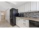 Kitchen area with black appliances, tile backsplash, and white cabinets at 4918 N 74Th St, Scottsdale, AZ 85251