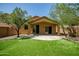 Backyard with covered patio, synthetic grass, and mature trees providing shade at 5125 E Juana Ct, Cave Creek, AZ 85331