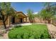 Backyard featuring synthetic grass, a covered patio, and a retaining wall at 5125 E Juana Ct, Cave Creek, AZ 85331
