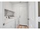 Bright laundry room with wood-look flooring, white washer and dryer, plus convenient shelving at 5125 E Juana Ct, Cave Creek, AZ 85331