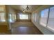 Open-concept living room with tile and carpet flooring, ceiling fan, and multiple windows at 5374 N Ormondo Way, Litchfield Park, AZ 85340