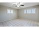Bright bedroom featuring tile flooring, plantation shutters on the windows, and a modern ceiling fan at 5618 E Des Moines St, Mesa, AZ 85205