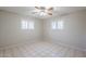 A neutral bedroom with tile floors, shuttered windows, and a ceiling fan at 5618 E Des Moines St, Mesa, AZ 85205