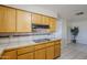 Efficient kitchen layout with wooden cabinetry, sleek cooktop, and adjacent breakfast nook at 5618 E Des Moines St, Mesa, AZ 85205