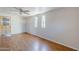 Bright living room featuring wood floors, three windows allowing for ample natural lighting, and a ceiling fan at 5618 E Des Moines St, Mesa, AZ 85205