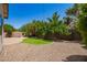 Landscaped backyard featuring an outdoor firepit area, trees, and a grassy patch at 595 W Dragon Tree Ave, Queen Creek, AZ 85140