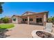 A covered patio extends from home to a backyard with a firepit and green turf at 595 W Dragon Tree Ave, Queen Creek, AZ 85140