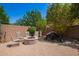 An inviting outdoor patio with a charming firepit and soothing waterfall feature surrounded by mature trees at 595 W Dragon Tree Ave, Queen Creek, AZ 85140