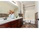A full bathroom features a double sink vanity, bathtub and shower at 595 W Dragon Tree Ave, Queen Creek, AZ 85140