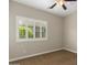 A carpeted bedroom features a ceiling fan and plantation shutters at 595 W Dragon Tree Ave, Queen Creek, AZ 85140