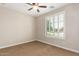A cozy carpeted bedroom with a ceiling fan and bright window shutters at 595 W Dragon Tree Ave, Queen Creek, AZ 85140