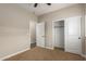 A tan carpeted bedroom with a closet and interior doors at 595 W Dragon Tree Ave, Queen Creek, AZ 85140