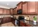 Gourmet kitchen with dark cabinetry, granite countertops, and a black cooktop at 595 W Dragon Tree Ave, Queen Creek, AZ 85140