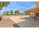 Large backyard with a covered patio, hardscape area, and lush landscaping overlooking a golf course at 636 S Rosemont --, Mesa, AZ 85206
