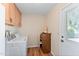 Functional laundry room featuring storage cabinets, laminate wood flooring, and access to the outdoors at 636 S Rosemont --, Mesa, AZ 85206
