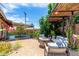 Backyard retreat featuring a cozy seating area with a fire pit, lush greenery, and a pergola at 6749 E Lewis Ave, Scottsdale, AZ 85257