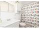 Well-lit bathroom with a shower featuring a patterned curtain, along with a white vanity at 6749 E Lewis Ave, Scottsdale, AZ 85257