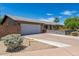 Single-story home featuring a two car garage, desert landscaping, and well-maintained facade at 6749 E Lewis Ave, Scottsdale, AZ 85257