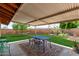 Spacious covered patio with an outdoor dining set, overlooking the lush green lawn at 6749 E Lewis Ave, Scottsdale, AZ 85257