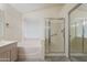 Bathroom featuring a separate soaking tub, large glass enclosed shower, and wood cabinets at 7345 E Forge Ave, Mesa, AZ 85208