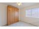 Cozy bedroom features a large wardrobe and a bright window with blinds at 7345 E Forge Ave, Mesa, AZ 85208