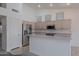 Kitchen area with stainless steel refrigerator and breakfast bar, open to the living area at 7345 E Forge Ave, Mesa, AZ 85208