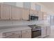 Kitchen boasts stainless steel oven, microwave, and ample white cabinetry and counter space at 7345 E Forge Ave, Mesa, AZ 85208