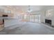 Bright living area with fireplace, open floor plan, and kitchen view with access to outdoor area at 7345 E Forge Ave, Mesa, AZ 85208