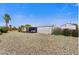 Spacious home featuring covered parking, low-maintenance gravel landscaping, and vibrant flowering bushes at 7711 E Farmdale Ave, Mesa, AZ 85208