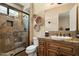 Bathroom with a glass shower stall and dark wood cabinets with a granite countertop at 7731 E Soaring Eagle Way, Scottsdale, AZ 85266