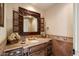 Bathroom vanity with a decorative mirror and dark wood cabinets and drawers at 7731 E Soaring Eagle Way, Scottsdale, AZ 85266