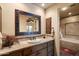 Bathroom with a unique wooden framed mirror and stone tiled vanity at 7731 E Soaring Eagle Way, Scottsdale, AZ 85266