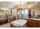 Bright bathroom featuring a jacuzzi bathtub with a window, and lots of cabinet space at 7731 E Soaring Eagle Way, Scottsdale, AZ 85266