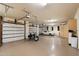 Spacious three-car garage featuring a motorcycle and a white luxury sedan at 7731 E Soaring Eagle Way, Scottsdale, AZ 85266