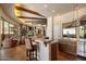 A kitchen features an island with barstool seating, stainless steel appliances, and wooden ceiling beams at 7731 E Soaring Eagle Way, Scottsdale, AZ 85266