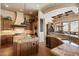 A kitchen features wooden cabinetry, an island, granite countertops, and stainless steel appliances at 7731 E Soaring Eagle Way, Scottsdale, AZ 85266