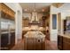 A kitchen features wooden cabinetry, a kitchen island, granite countertops, and stainless steel appliances at 7731 E Soaring Eagle Way, Scottsdale, AZ 85266