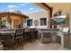 Outdoor kitchen and bar area with seating, a small refrigerator, and a sink at 7731 E Soaring Eagle Way, Scottsdale, AZ 85266